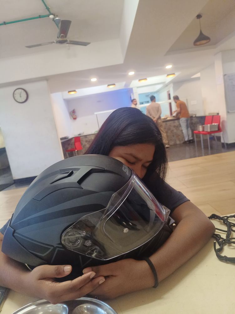 Shruti resting her head on a helmet, taking a break