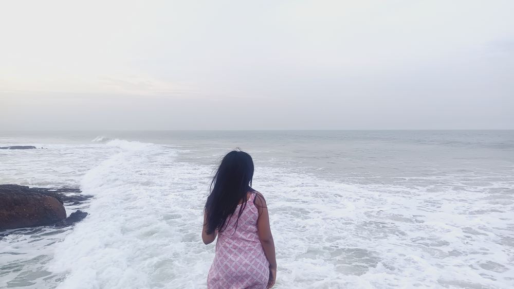 Shruti from behind, watching the waves roll in